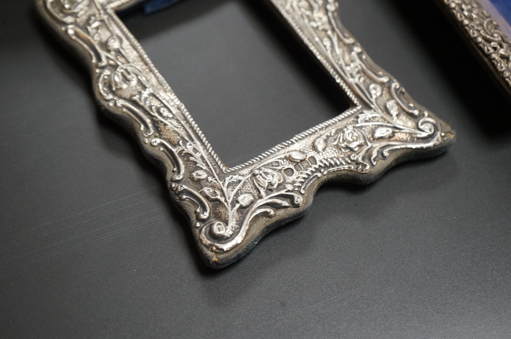 A late Victorian repousse silver mounted rectangular photograph frame, Birmingham, 1898, 17.9cm, a smaller Edwardian silver mounted photograph frame, Williams Ltd, Birmingham, 1905 and a set of four modern silver mounted